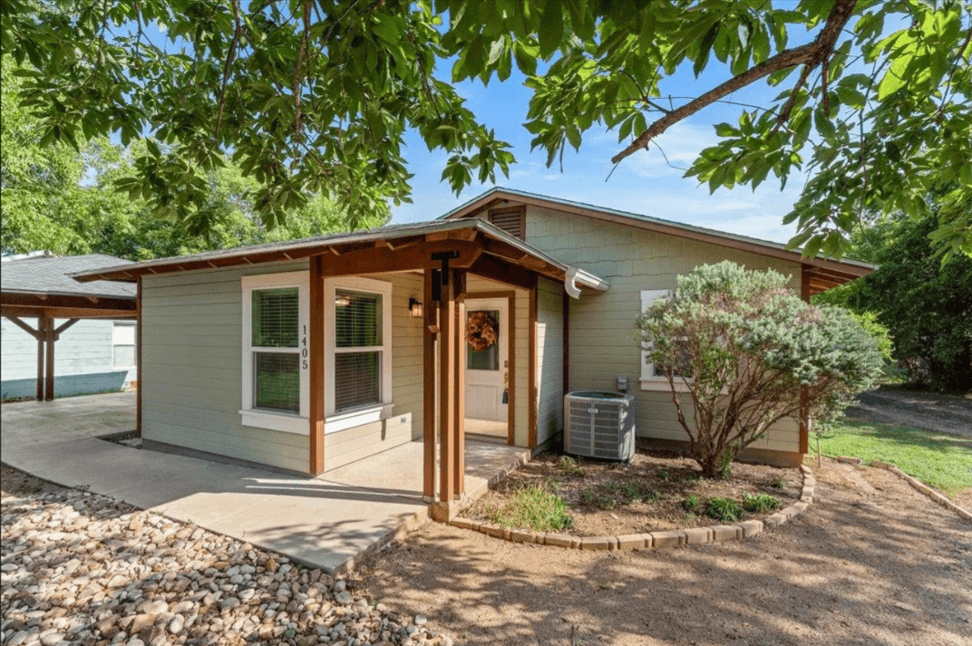 1405 Johnson St, Marble Falls, TX 78654 — single-story sage-green home with covered front porch, listed by D. Green & Associates