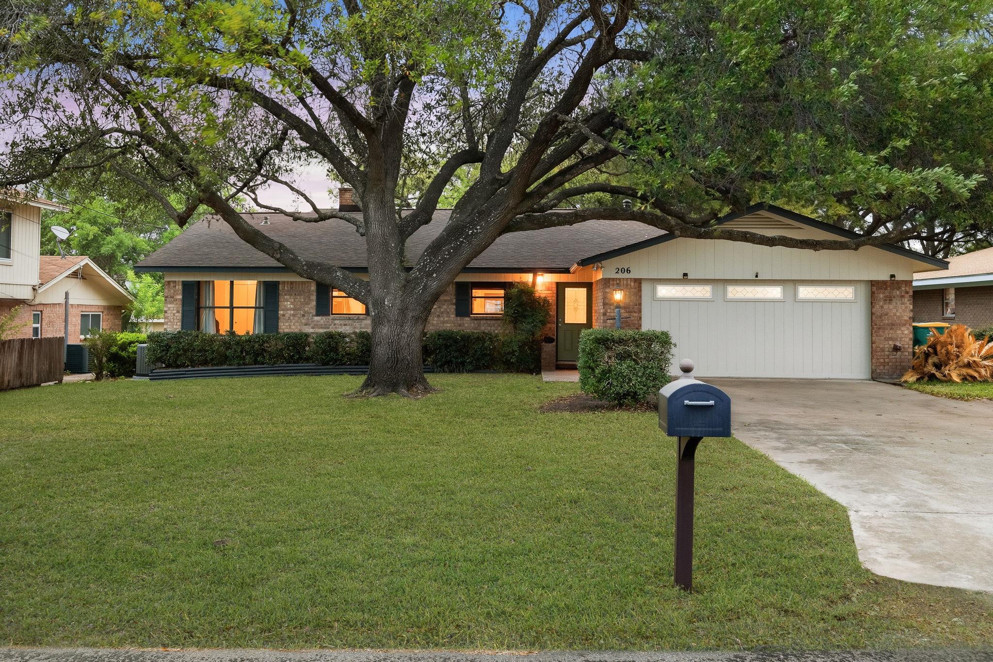 206 E Pheasant Rd, Highland Haven, TX 78654 — remodeled 3-bedroom lakefront home on Lake LBJ with mature oak tree and two-car garage, listed by D. Green & Associates